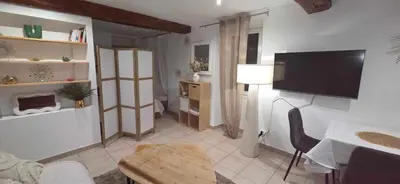 a living room with a flat screen tv on the wall at Studio en centre ville a 2 minutes de la plage in Ajaccio