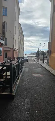 an empty street with buildings and the ocean in the distance at Studio en centre ville a 2 minutes de la plage in Ajaccio