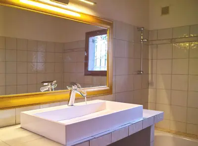 a bathroom with a white sink and a mirror at Casa with pool near Palombaggia in Porto-Vecchio