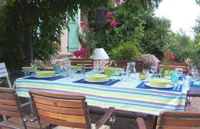 a table with a blue and white striped table cloth at Casa with pool near Palombaggia in Porto-Vecchio