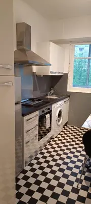 a kitchen with a black and white checkered floor at Immeuble Imperial in Corte