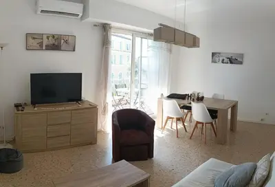 a living room with a television and a table and chairs at Immeuble Imperial in Corte