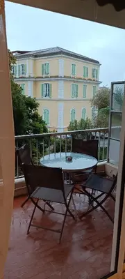 a table and chairs on a balcony with a building at Immeuble Imperial in Corte