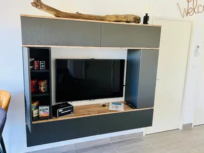 a entertainment center with a television in a living room at Alivu Immurtale - T3 design standing & confort, terrasse XXL in Propriano