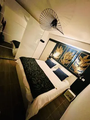 a bedroom with a large bed with a fan on the wall at Alivu Immurtale - T3 design standing & confort, terrasse XXL in Propriano