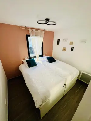 a bedroom with a large white bed with a window at Alivu Immurtale - T3 design standing & confort, terrasse XXL in Propriano