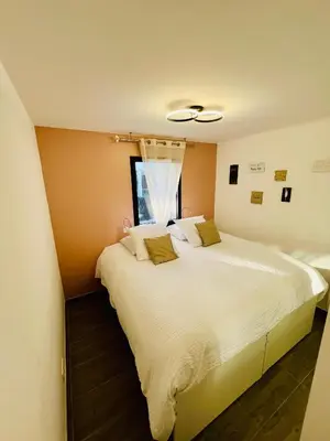 a bedroom with a large white bed with a window at Alivu Immurtale - T3 design standing & confort, terrasse XXL in Propriano