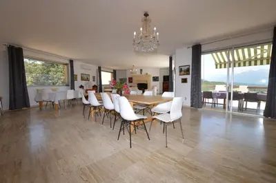 a dining room with a table and white chairs at Villa la Chiosella in Valle-di-Mezzana