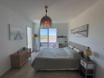 a bedroom with a bed and a large window at Villa Oletta, Saint Florent in Oletta