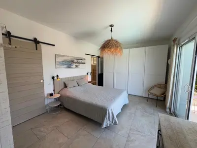 a bedroom with a bed and a large window at Villa Oletta, Saint Florent in Oletta