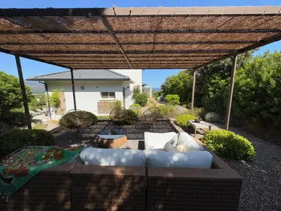 a patio with a couch under a pergola at Villa Oletta, Saint Florent in Oletta