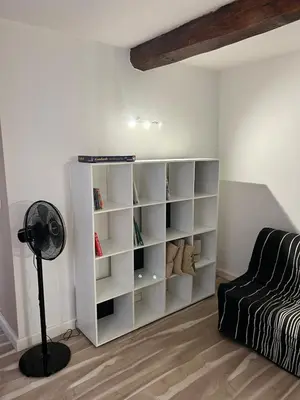 a room with a white book shelf next to a bed at Appartement centre historique Ajaccio in Ajaccio