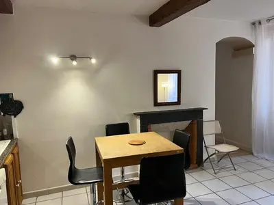 a dining room with a table and chairs and a fireplace at Appartement centre historique Ajaccio in Ajaccio