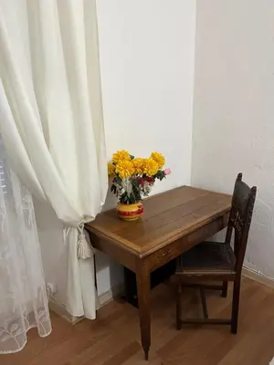 a wooden table with a vase of flowers on it at Casa Bella Centre de Corsica in Corte