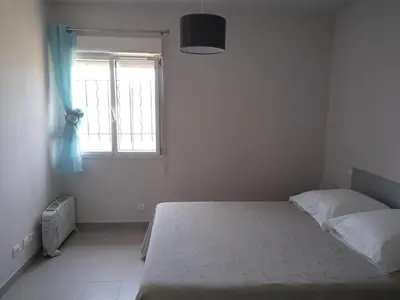 a bedroom with a bed and a window at Le Golfe in Figari