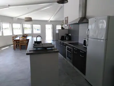 a kitchen with a white refrigerator and a table at Le Golfe in Figari