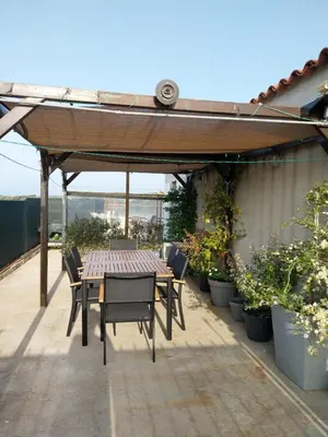 a table and chairs under a pergola on a patio at Le Golfe in Figari