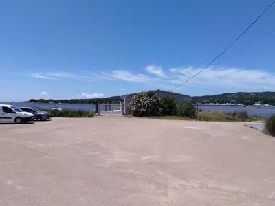 a parking lot with cars parked next to a body of water at Le Golfe in Figari