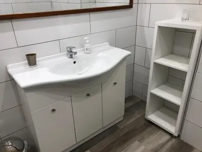 a bathroom with a white sink and shelves at Rez de villa, tout confort 4 pers parking Proche Ajaccio in Alata