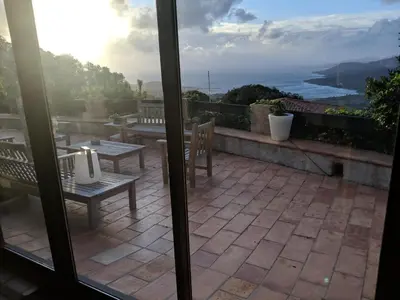 a patio with benches and a view of the ocean at Casa Campana in Viggianello