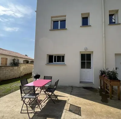 a pink table and chairs in front of a white house at Villa Canoe - Appartement 2 pièces in Santa-Maria-Poggio