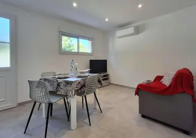a dining room with a table and chairs and a couch at Villa Canoe - Appartement 2 pièces in Santa-Maria-Poggio