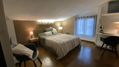 a bedroom with a bed and two chairs and a window at Cozy cocoon 300m de la plage in Borgo
