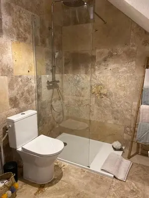 a bathroom with a toilet and a glass shower at Cozy cocoon 300m de la plage in Borgo