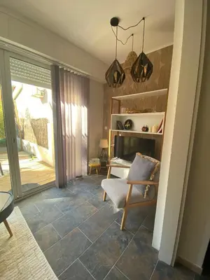 a living room with a chair and a sliding glass door at Cozy cocoon 300m de la plage in Borgo