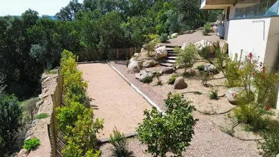 a garden with rocks and plants next to a house at Villa neuve d'exception 6ch SPA Piscine in Conca