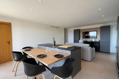 a kitchen and living room with a table and chairs at Villa neuve d'exception 6ch SPA Piscine in Conca