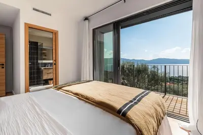 a bedroom with a bed and a large window at Magnifique villa 6 chambres avec piscine,Olmeto plage in Olmeto