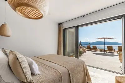 a bedroom with a bed and a view of the ocean at Magnifique villa 6 chambres avec piscine,Olmeto plage in Olmeto