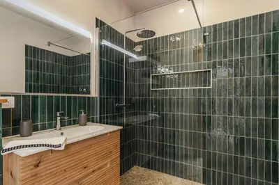 a bathroom with a sink and a shower with green tiles at Magnifique villa 6 chambres avec piscine,Olmeto plage in Olmeto
