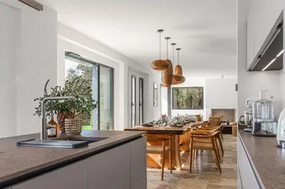 a kitchen and dining room with a table and a dining room with a dining table at Magnifique villa 6 chambres avec piscine,Olmeto plage in Olmeto