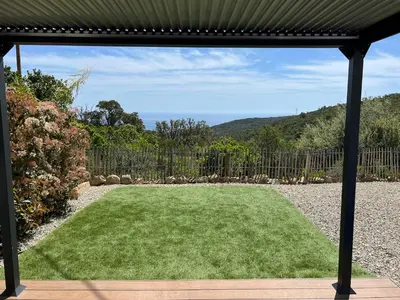 a yard with a large lawn with a fence at Charmant appartement en Rez-de-chaussée de VILLA - Classification 3 étoiles in Sari Solenzara