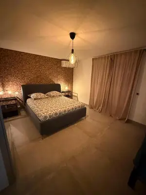 a bedroom with a bed and a brick wall at Charmant appartement en Rez-de-chaussée de VILLA - Classification 3 étoiles in Sari Solenzara