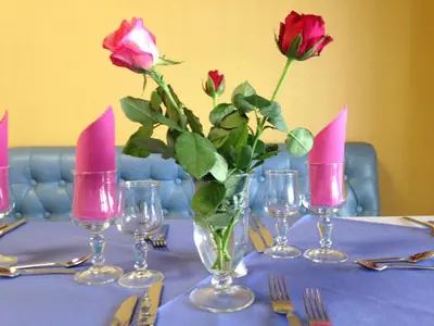 a table with roses in a vase with pink candles at Hotel le Dauphin in Ajaccio