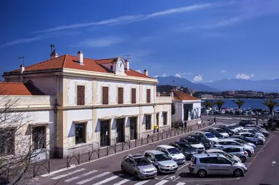 a parking lot with cars parked in front of a building at Hotel le Dauphin in Ajaccio