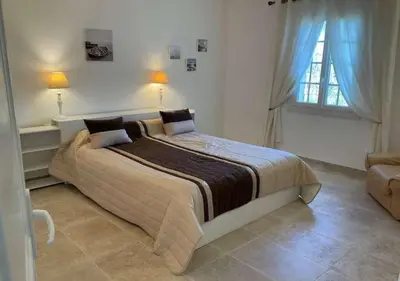 a bedroom with a large bed and a window at A Filetta, Maquis & mer, dans un hameau de charme in Sartène