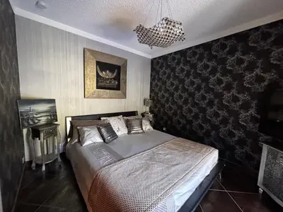 a bedroom with a bed and a chandelier at E Case Di Pietralba in Ajaccio