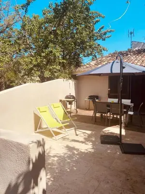 a patio with chairs and a table and a fence at Maison en corse in Santa-Maria-Poggio