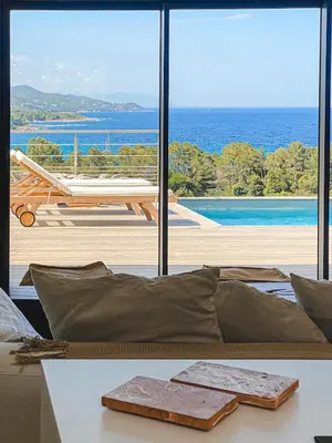 a living room with a table and a view of the ocean at Villa Margaux with private pool & sea view in Conca