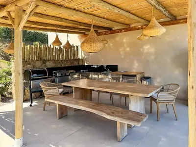 a wooden table and chairs under a pavilion at Villa Margaux with private pool & sea view in Conca
