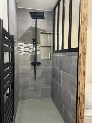a bathroom with a shower with gray tiles at Appartement cosy centre ville in Ajaccio