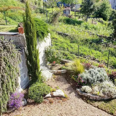 a garden with flowers and plants on a hill at Logement T2 Villa Bavella Vista in Quenza