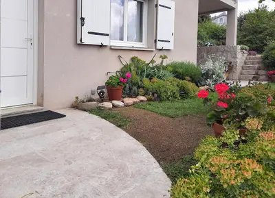 a front yard with flowers and a house at Logement T2 Villa Bavella Vista in Quenza
