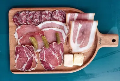 a wooden cutting board with meat and cheese on it at Logement T2 Villa Bavella Vista in Quenza