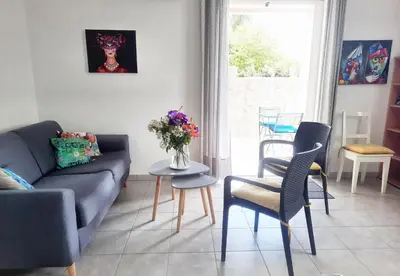 a living room with a couch and a table with flowers on it at Logement T2 Villa Bavella Vista in Quenza