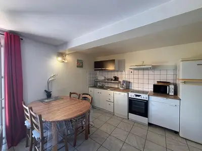 a kitchen with a wooden table and a table and chairs at Rez de villa de 45 m2 Afa calme et fleuri in Afa